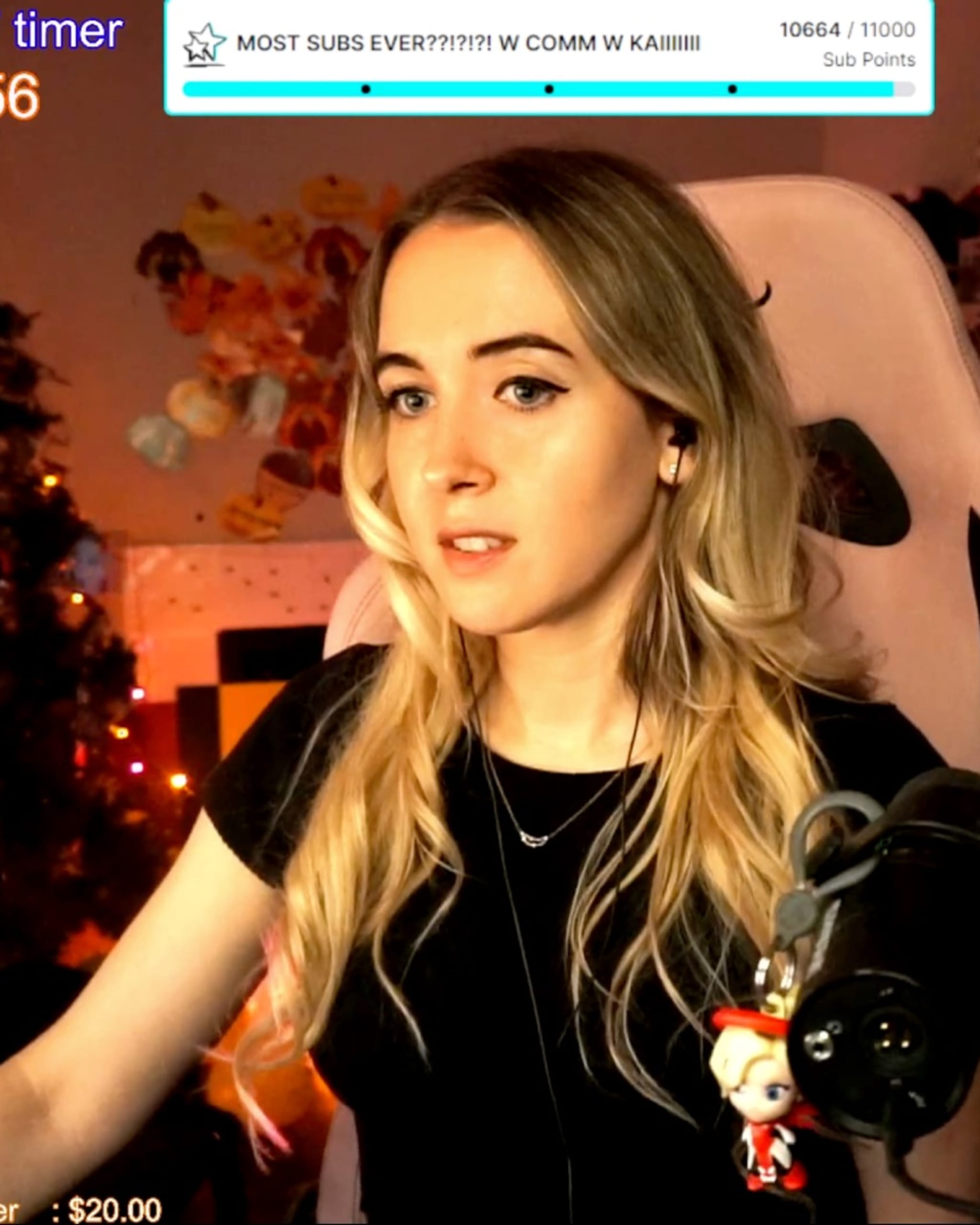 Emilycc sits in her room while livestreaming on Twitch, with a chatbox on the lower right and other text surrounding her.